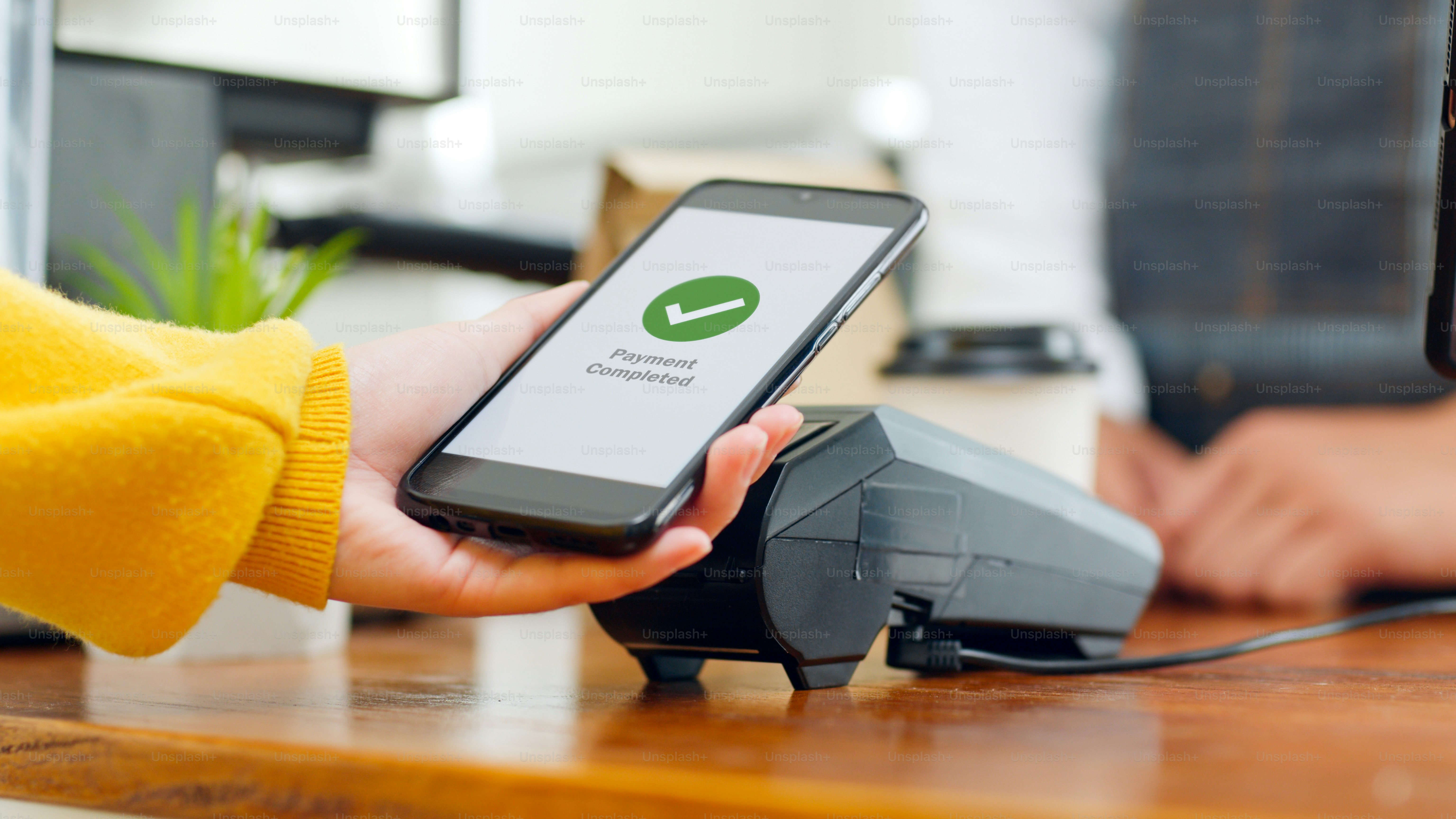 Customer using smartphone for NFC payment at cafe restaurant, cashless, contactless technology and money transfer concept
